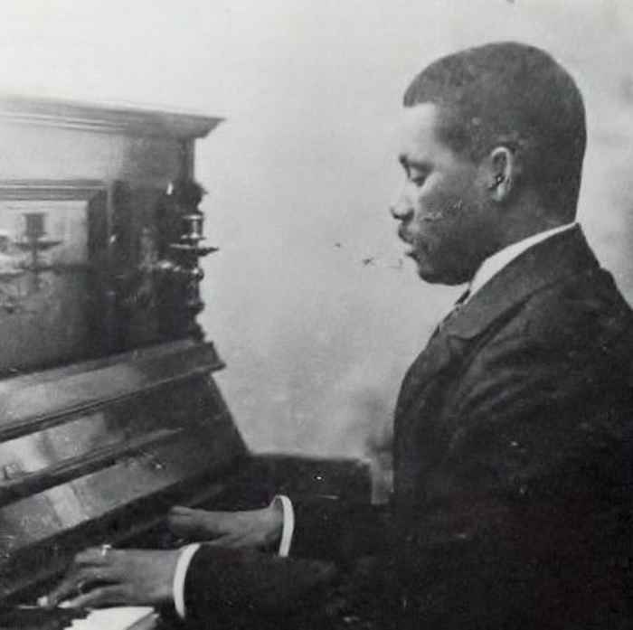 Een zwart en wit foto van de Surinaamse componist Johannes N. Helstone